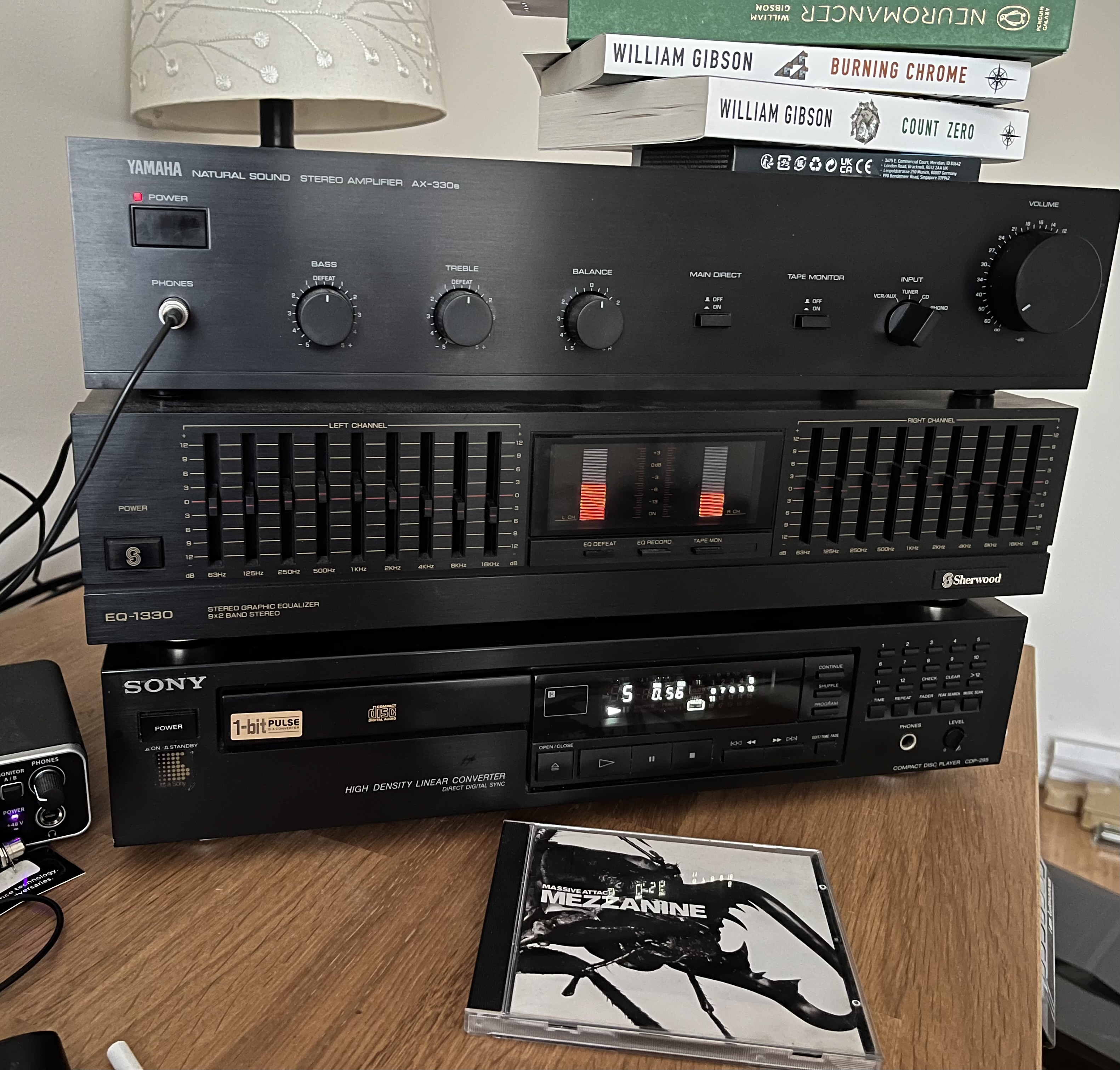 /images/hifi.jpg A stack of HiFi equipment, on a desk. The top of the stack has three books on top - Neuromancer, Burning Chrome and Count Zero by William Gibson. The top unit is a Yamaha AX-330e, which is powered on. It has a volume knob, input selection dial, main direct and tape monitor switch, and 3 smaller dials labelled Bass, Treble and Balance. Headphones are plugged in. Below it, is the EQ-1330 previously mentioned in this post, and it's powered on and shows two VU meters illuminated. Below this, is the Sony CD-295, playing track 5 of Mezzanine by Massive Attack. The CD case for Mezzanine is in front of the CD player.